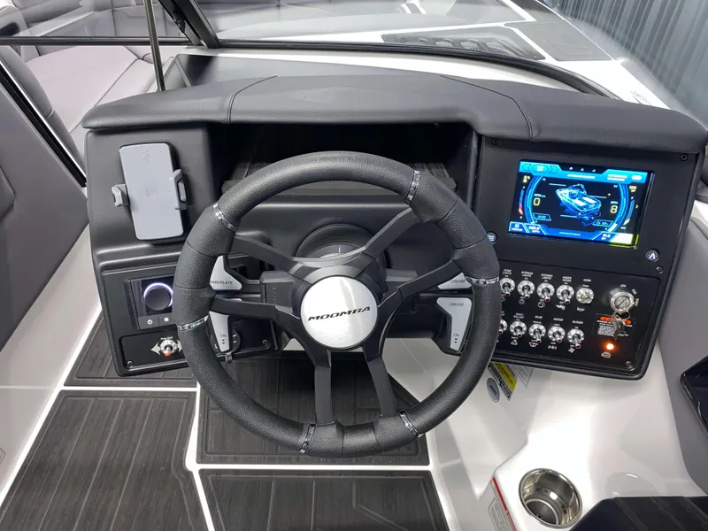 Slide: The Image of 2025 Moomba Max boat dashboard with steering wheel and digital display. - 12