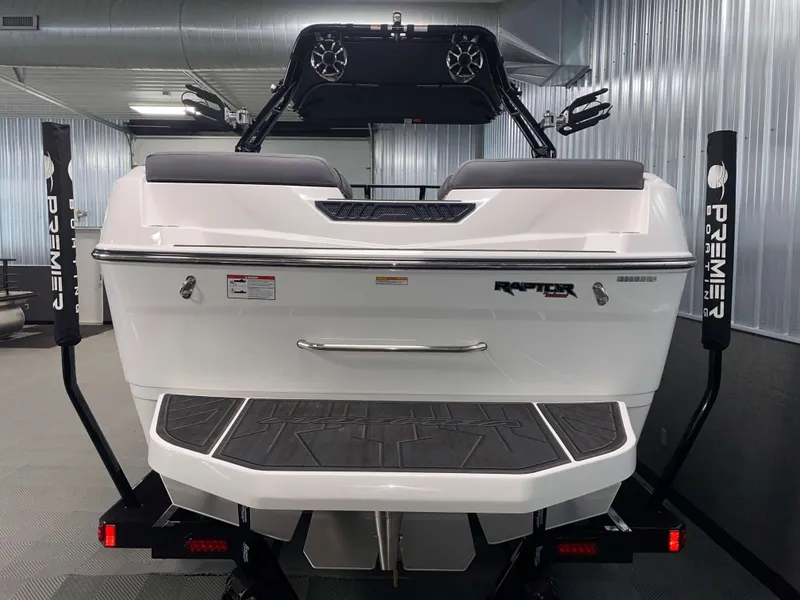 Slide: The Image of 2025 Moomba Max boat rear view in a showroom, featuring Raptor engine branding. - 23