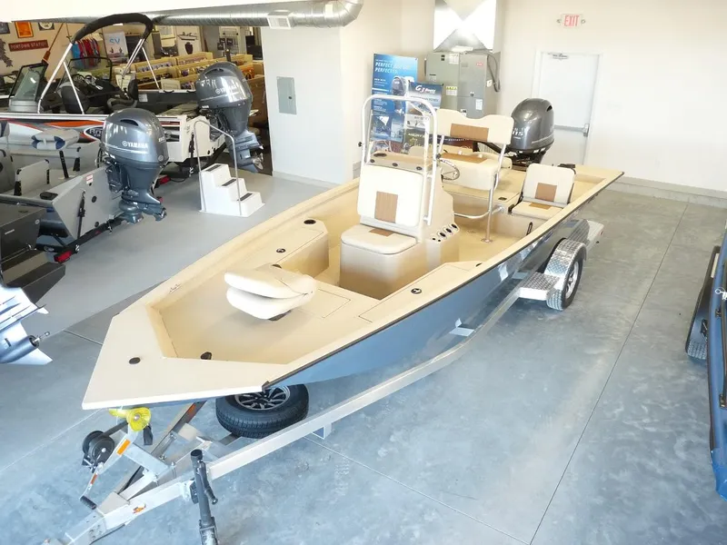 The Image of 2025 G3 Bay 19 GX boat on trailer in showroom, featuring dual outboard motors. - 0