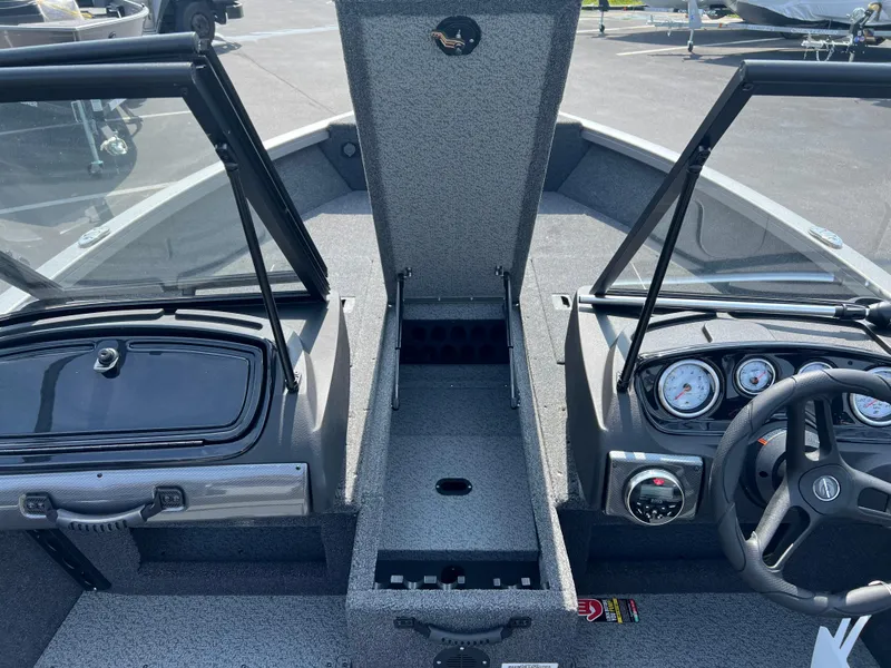 Slide: The Image of 2024 Crestliner 1650 Hawk WT boat interior with open storage and dashboard view. - 10