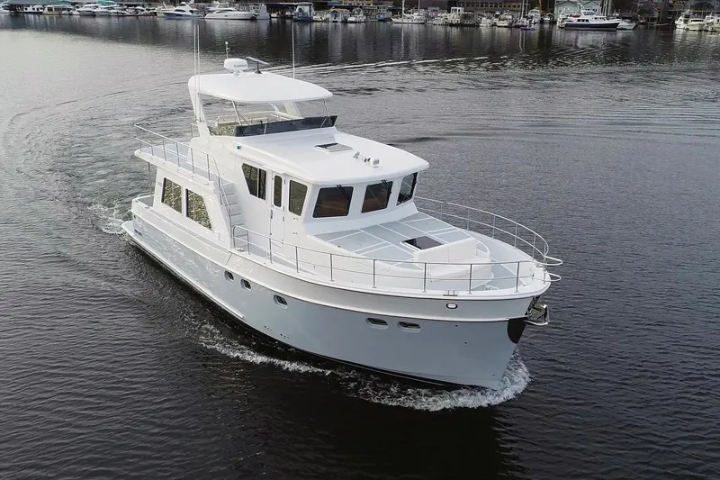 Slide: The Image of 2026 Helmsman Trawlers 46 Pilothouse yacht cruising on calm waters. - 1