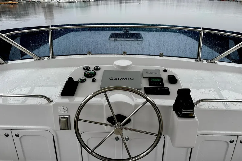 Slide: The Image of Helmsman Trawlers 46 Pilothouse 2026 helm with Garmin navigation system on a rainy day. - 20