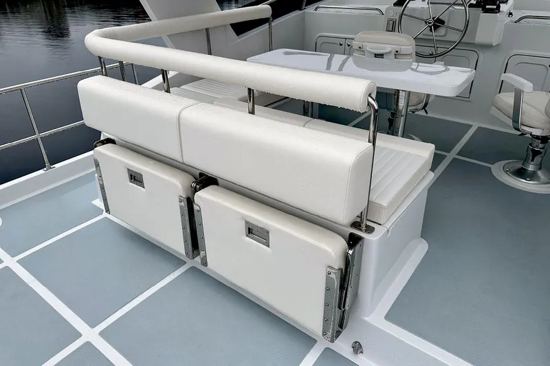 Slide: The Image of Helmsman Trawlers 46 Pilothouse 2026 boat seating area with white cushioned benches. - 22