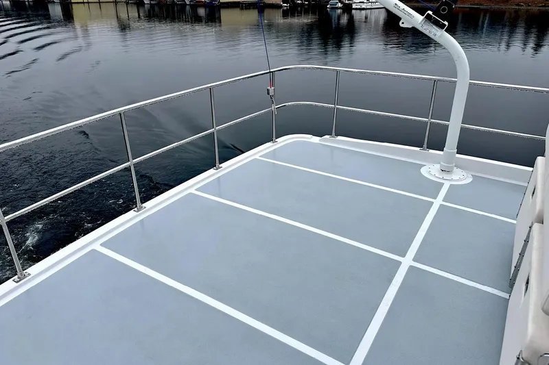 Slide: The Image of Rooftop deck of 2026 Helmsman Trawlers 46 Pilothouse, overlooking calm marina waters. - 23