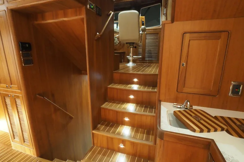 Slide: The Image of Luxurious interior of 2026 Helmsman Trawlers 46 Pilothouse with wooden stairs and cabinetry. - 30
