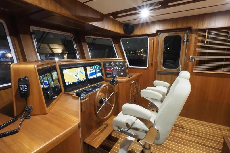 Slide: The Image of 2026 Helmsman Trawlers 46 Pilothouse interior with modern navigation equipment and wooden finish. - 32