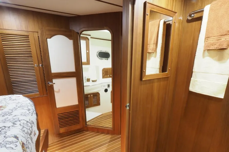Slide: The Image of 2026 Helmsman Trawlers 46 Pilothouse interior with wood paneling and bathroom view. - 42