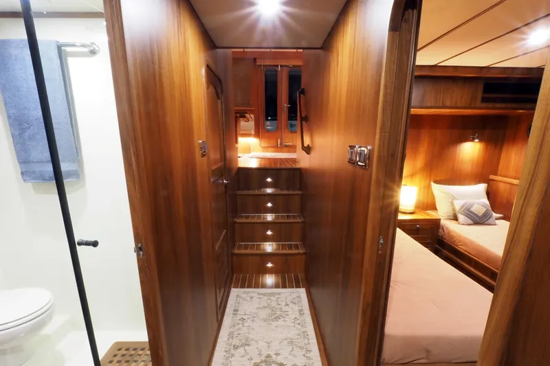 Slide: The Image of Luxurious interior of 2026 Helmsman Trawlers 46 Pilothouse with wood finish and cozy bedroom. - 48