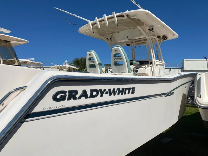 Slide: The Image of 2015 Grady-White Canyon 306 boat, white exterior, clear blue sky background. - 2