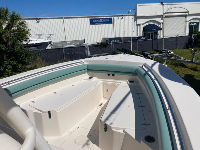 Slide: The Image of 2015 Grady-White Canyon 306 boat with spacious seating, docked near a marine facility. - 3