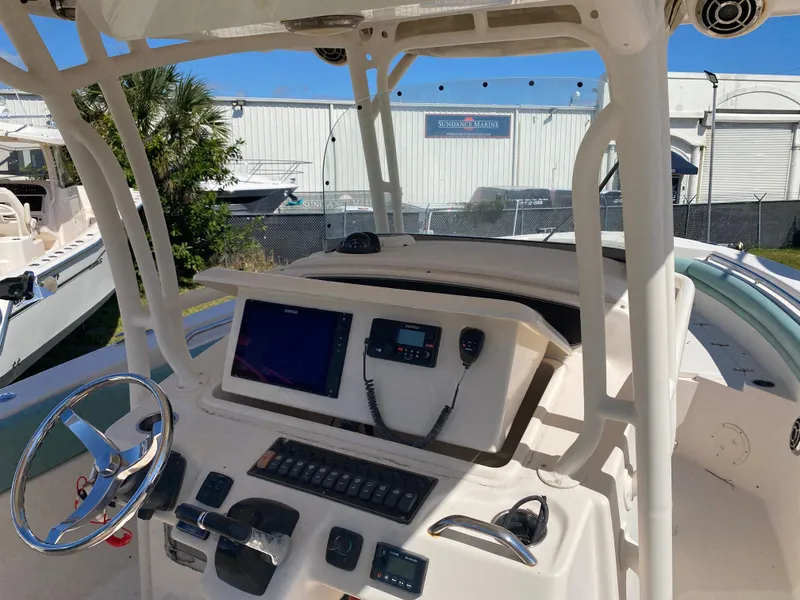 Slide: The Image of 2015 Grady-White Canyon 306 boat dashboard with steering wheel and navigation controls. - 5