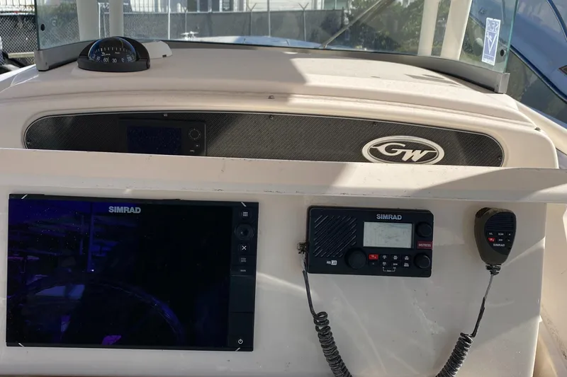 Slide: The Image of 2015 Grady-White Canyon 306 dashboard with Simrad electronics and communication devices. - 6