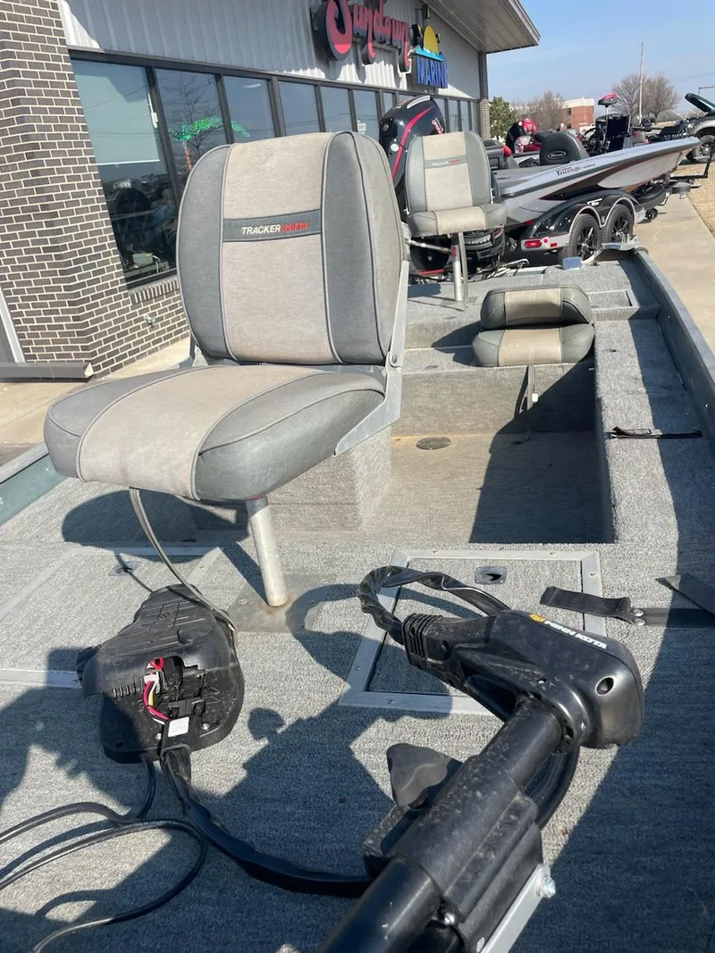 Slide: The Image of 1987 Tracker Tournament TV-17 boat interior with seating and equipment, parked outside a building. - 6