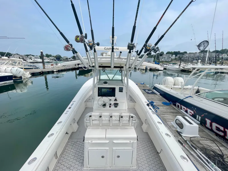 Slide: The Image of Regulator 32FS boat helm with joystick, fishing rods, and Garmin equipment at marina, 2006 model. - 11