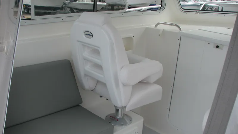 Slide: The Image of 2024 NorthCoast 255HT interior with white captain's chair and gray seating. - 12