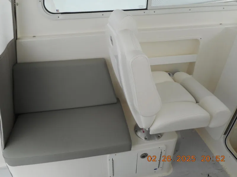 Slide: The Image of 2024 NorthCoast 255HT boat interior seating with white and gray cushions. - 34