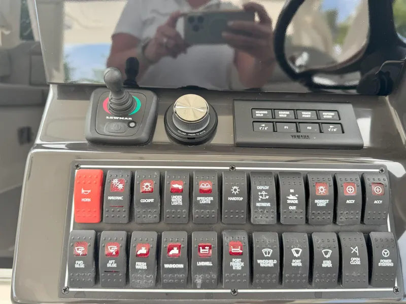 Slide: The Image of Control panel of 2025 Pursuit OS 355 Offshore boat with various switches and joystick. - 21