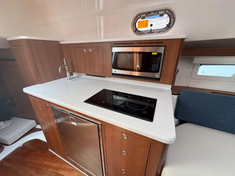 Slide: The Image of 2025 Pursuit OS 355 Offshore yacht kitchen with stove, microwave, and sink. - 27
