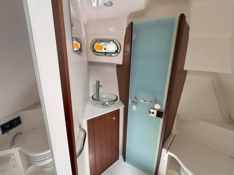 Slide: The Image of 2025 Pursuit OS 355 Offshore boat bathroom with glass sink and frosted door. - 28