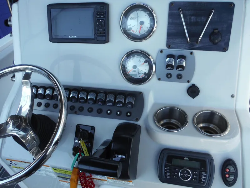 Slide: The Image of 2019 Hurricane Center Console 21 OB dashboard with gauges, controls, and steering wheel. - 18