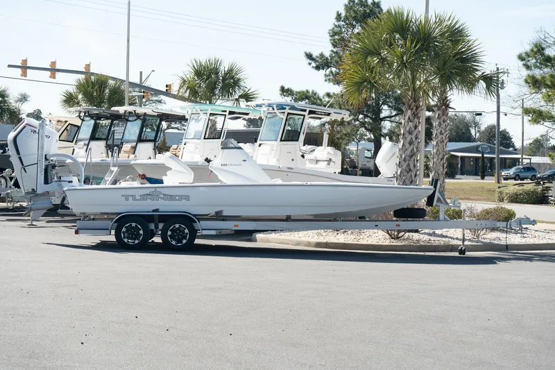 Slide: The Image of 2025 Turner Boatworks 24 SAVAGE on trailer, parked outdoors near palm trees. - 3