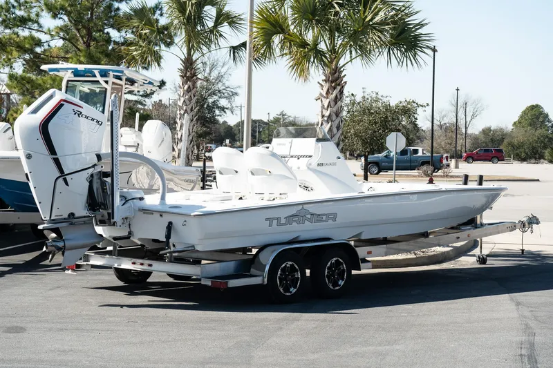 Slide: The Image of 2025 Turner Boatworks 24 SAVAGE on trailer, parked near palm trees. - 4