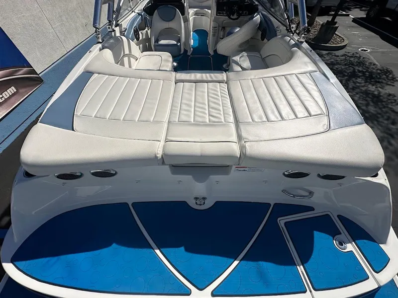 Slide: The Image of 2012 Bayliner 235 Bowrider boat interior with white seating and blue flooring. - 10