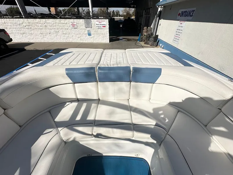 Slide: The Image of 2012 Bayliner 235 Bowrider with white and blue seating in a sunny outdoor setting. - 13