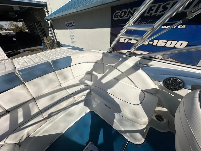 Slide: The Image of 2012 Bayliner 235 Bowrider interior with white seating and blue accents. - 15