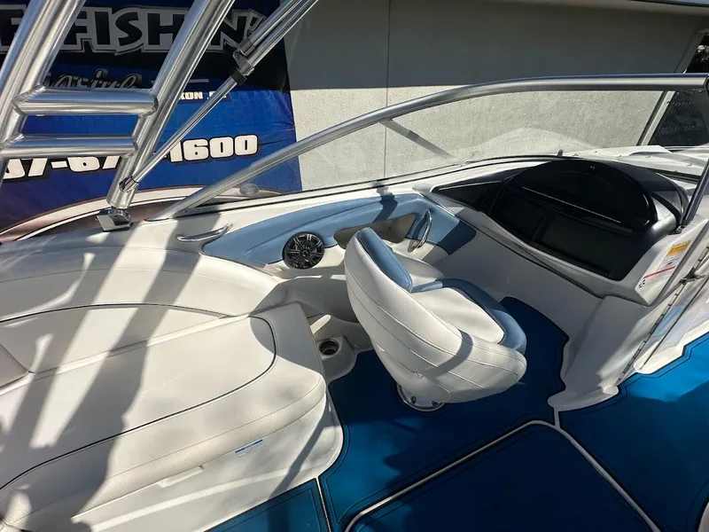 Slide: The Image of 2012 Bayliner 235 Bowrider interior with white seating and blue flooring. - 16