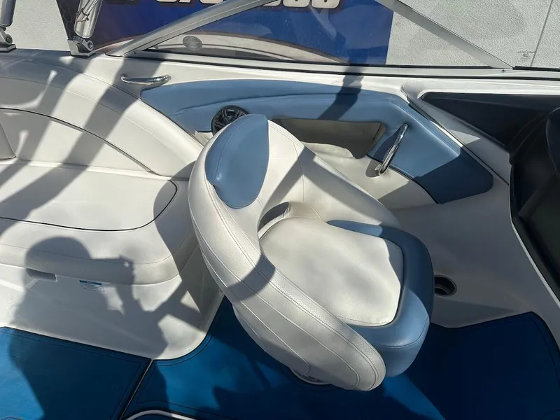 Slide: The Image of Interior of 2012 Bayliner 235 Bowrider boat with white seating and blue accents. - 17