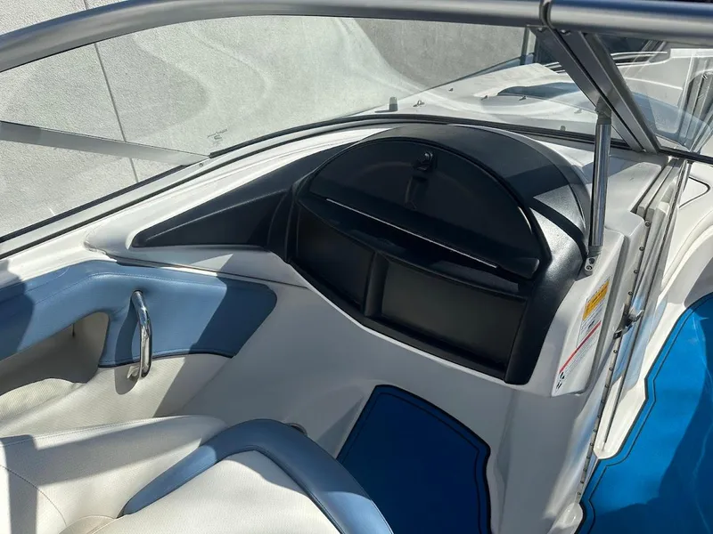 Slide: The Image of 2012 Bayliner 235 Bowrider interior, featuring blue and white seating with a sleek dashboard design. - 18