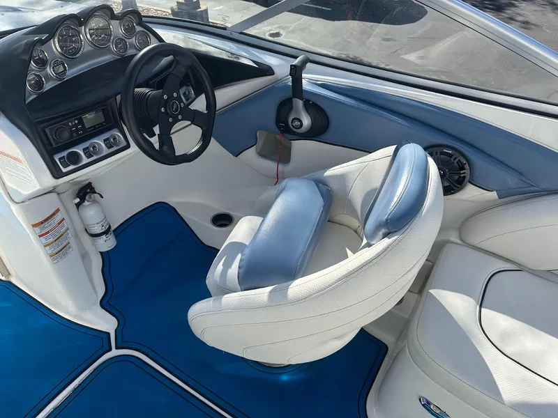 Slide: The Image of Interior of 2012 Bayliner 235 Bowrider boat with blue and white seating and dashboard. - 20