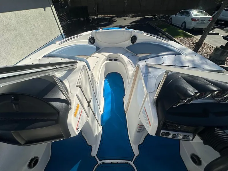 Slide: The Image of 2012 Bayliner 235 Bowrider interior with blue flooring and white seating. - 25