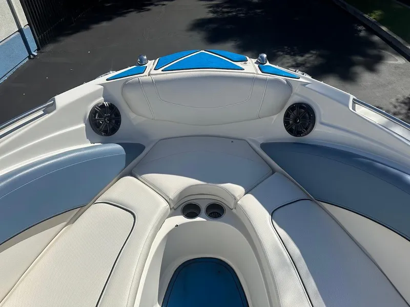Slide: The Image of 2012 Bayliner 235 Bowrider interior, featuring white and blue seating with built-in speakers. - 27