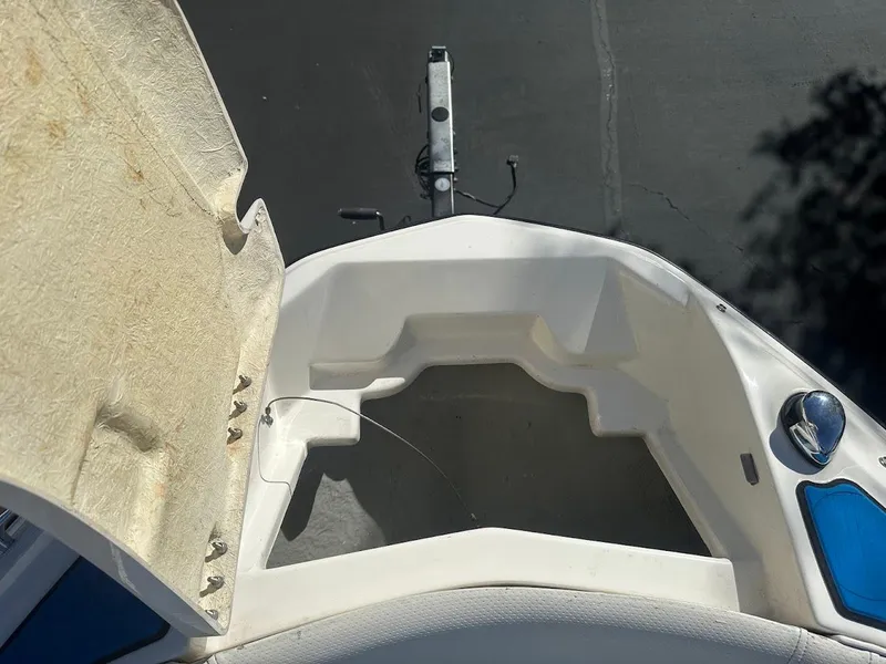 Slide: The Image of 2012 Bayliner 235 Bowrider boat interior, open storage compartment, sunny day. - 31