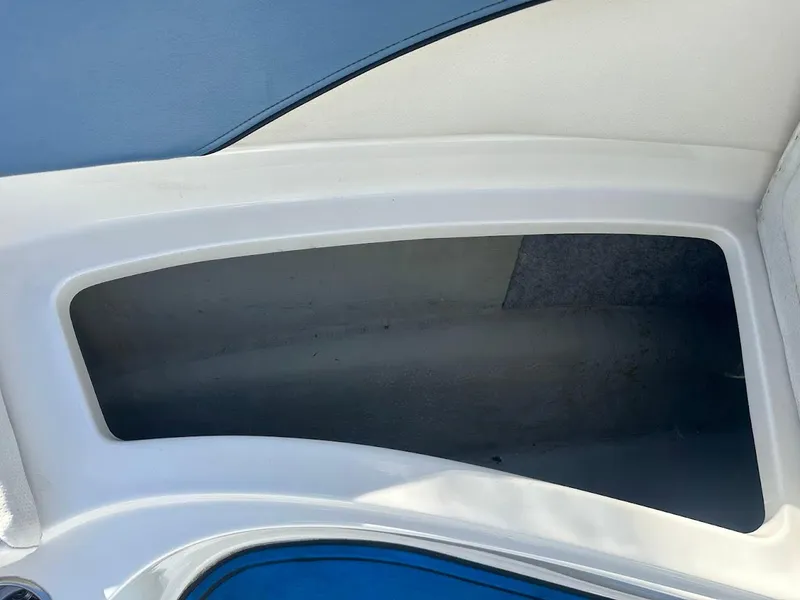 Slide: The Image of Storage compartment of a 2012 Bayliner 235 Bowrider boat, featuring sleek white interior design. - 35