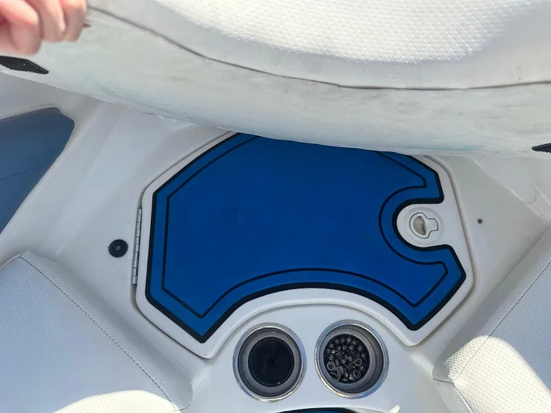 Slide: The Image of 2012 Bayliner 235 Bowrider interior with blue storage compartment and cup holders. - 36