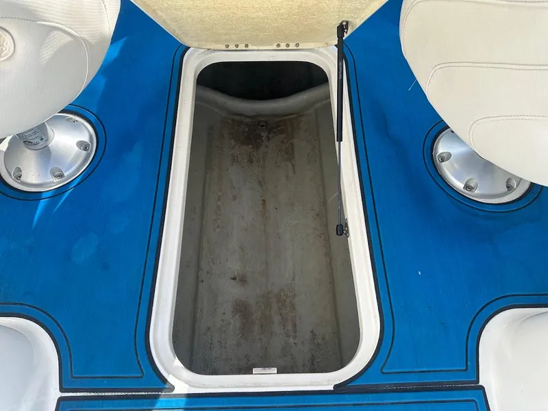 Slide: The Image of Open storage compartment on 2012 Bayliner 235 Bowrider boat with blue flooring. - 38