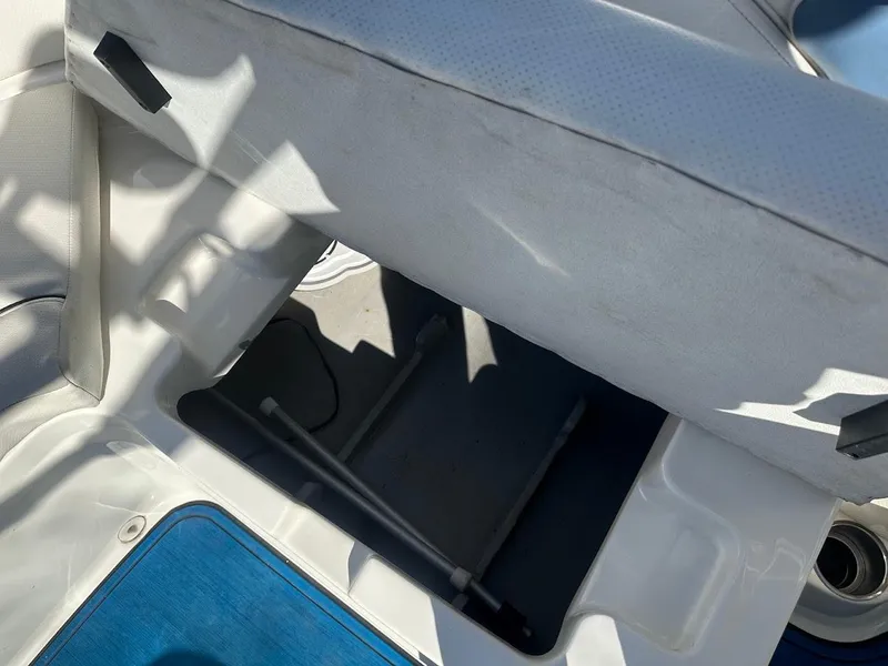 Slide: The Image of Storage compartment in 2012 Bayliner 235 Bowrider boat, open seat revealing interior space. - 39