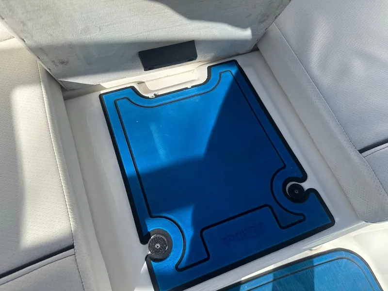 Slide: The Image of 2012 Bayliner 235 Bowrider interior with blue storage compartment cover. - 43