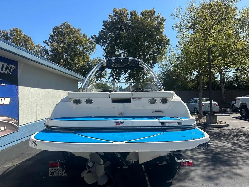 Slide: The Image of 2012 Bayliner 235 Bowrider boat, rear view, parked outdoors on a sunny day. - 7