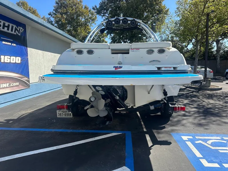 Slide: The Image of 2012 Bayliner 235 Bowrider boat parked in a lot, rear view. - 8