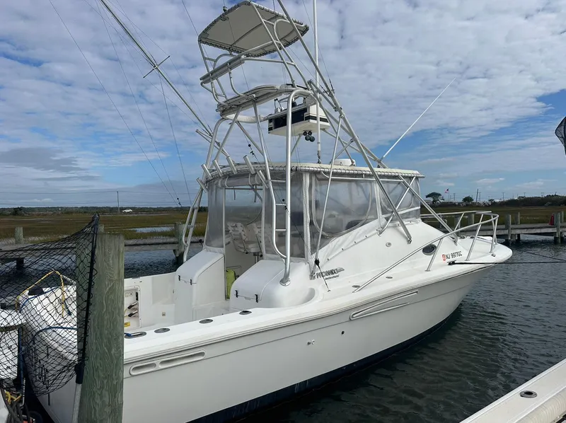 Slide: The Image of 1998 Phoenix 32 Tournament boat docked, featuring a white exterior and fishing tower. - 3