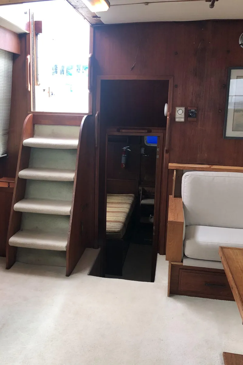 Slide: The Image of 1976 Tollycraft 48 Cockpit Motor Yacht interior with stairs and seating area. - 10