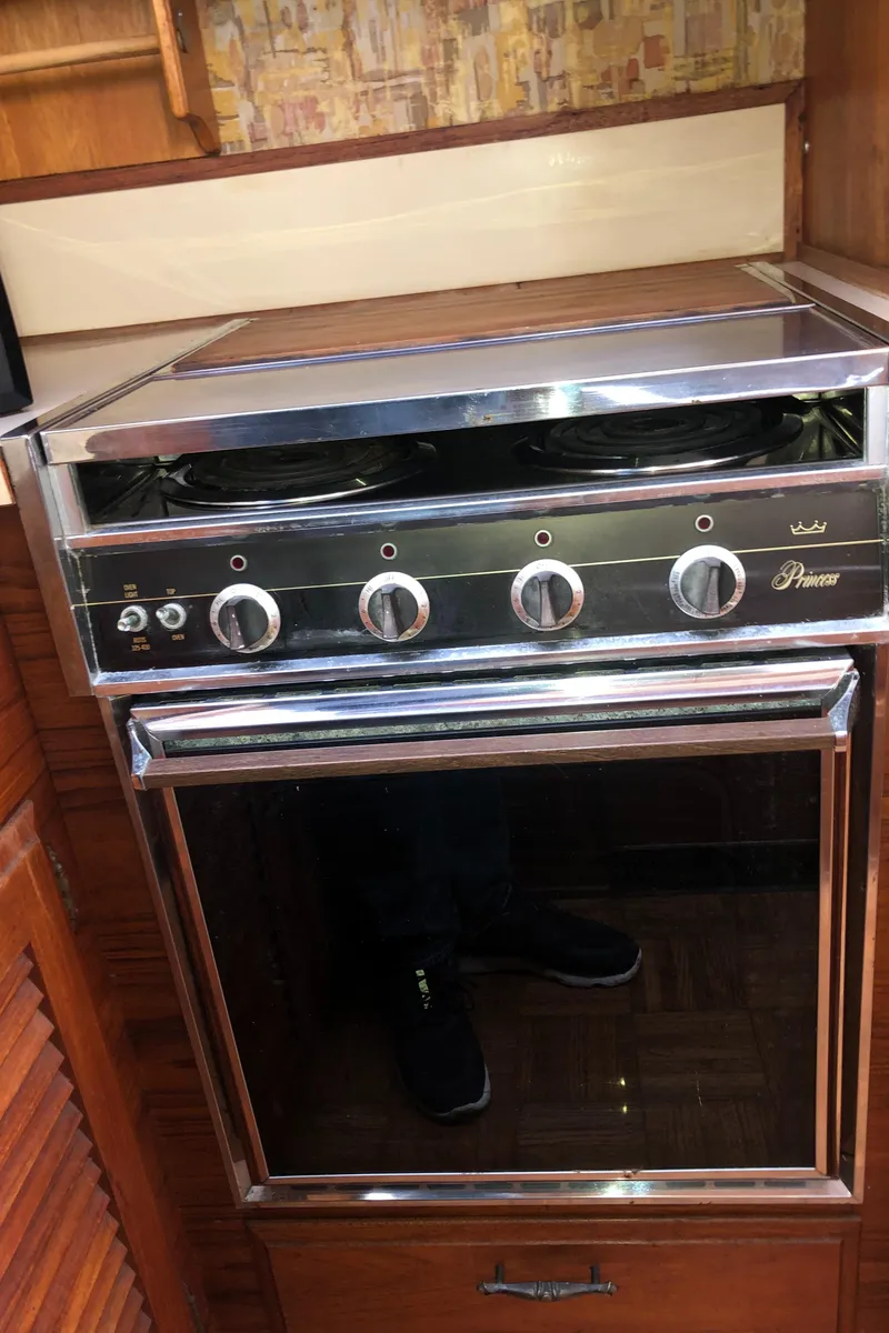 Slide: The Image of 1976 Tollycraft 48 Cockpit Motor Yacht kitchen stove with four burners and oven. - 14