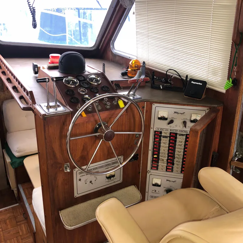 Slide: The Image of 1976 Tollycraft 48 Cockpit Motor Yacht helm with classic wooden dashboard and steering wheel. - 18