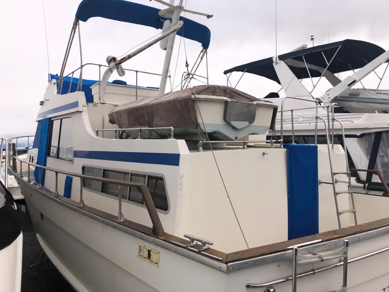 Slide: The Image of 1976 Tollycraft 48 Cockpit Motor Yacht with blue accents docked at a marina. - 2