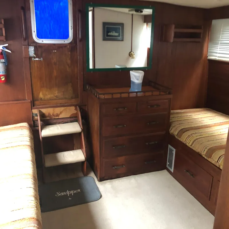 Slide: The Image of 1976 Tollycraft 48 Cockpit Motor Yacht interior with wooden cabinetry and twin beds. - 23