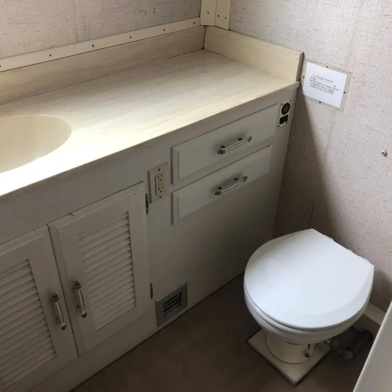 Slide: The Image of Bathroom interior of 1976 Tollycraft 48 Cockpit Motor Yacht, featuring sink and toilet. - 26